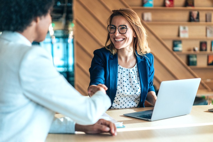 A female biotech CEO recruiter shaking hands with a candidate
